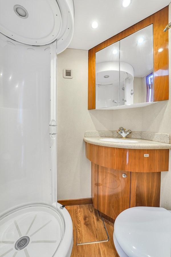 a bathroom with a sink and a mirror aboard HATTERAS 80 MOTOR Yacht for Sale