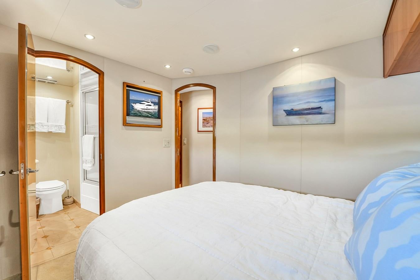 a bedroom with a bed and a closet aboard HATTERAS 80 MOTOR Yacht for Sale