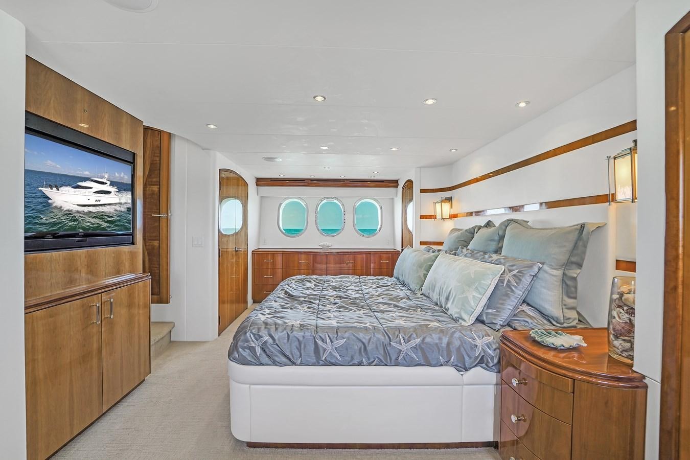 a bedroom with a bed and a tv aboard HATTERAS 80 MOTOR Yacht for Sale