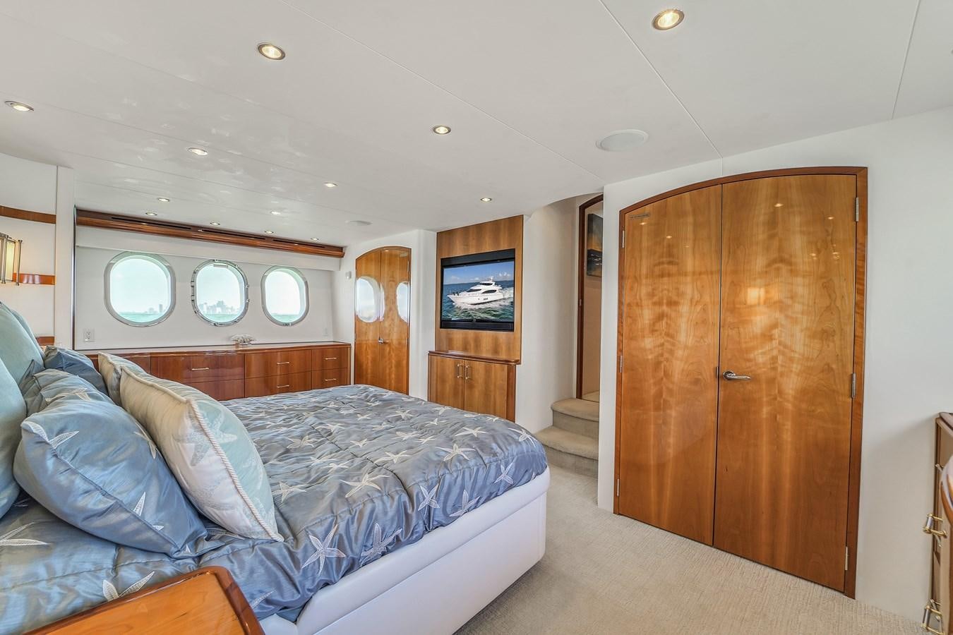a bedroom with a bed and a closet aboard HATTERAS 80 MOTOR Yacht for Sale