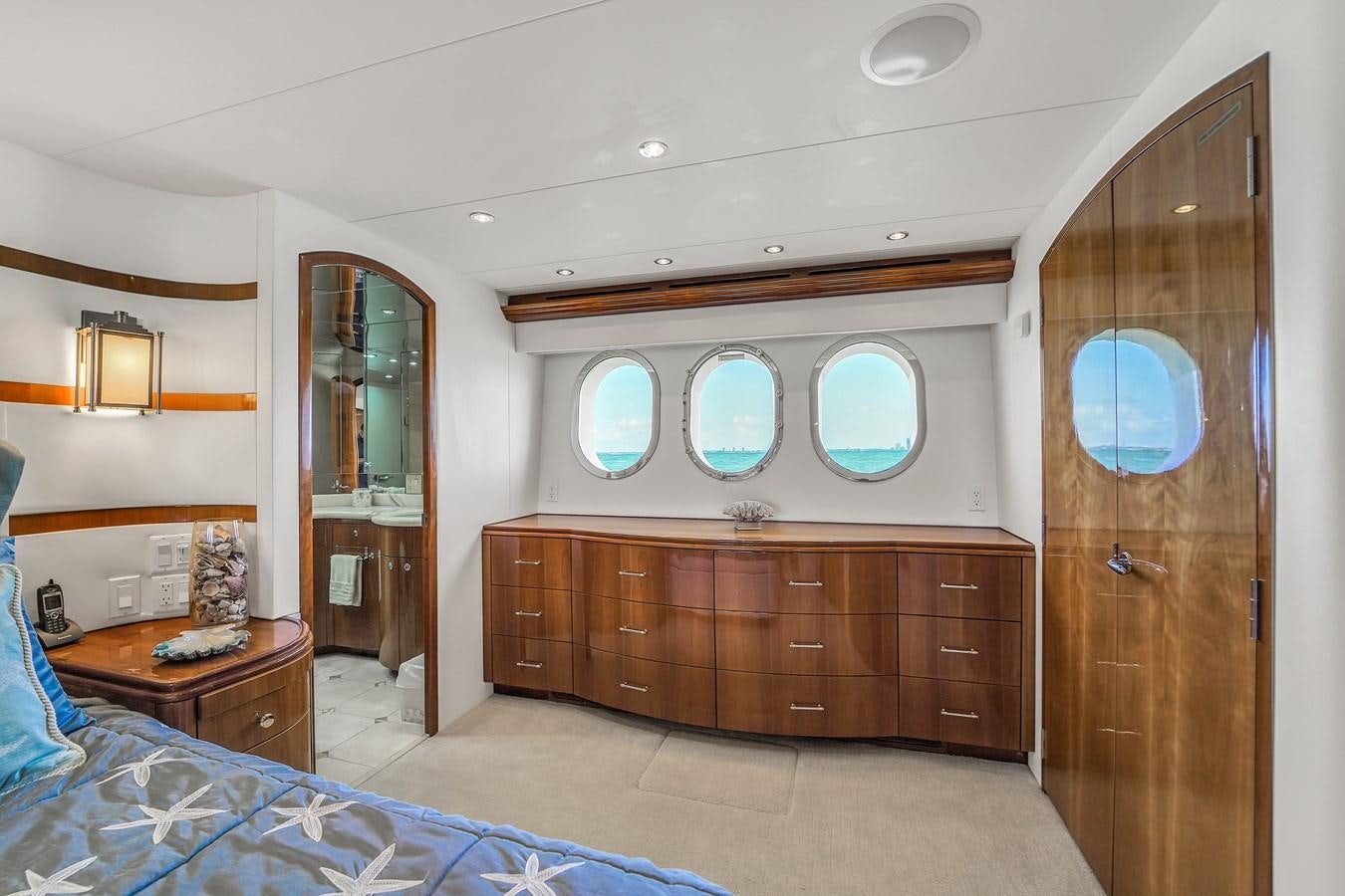 a room with a bed and a dresser aboard HATTERAS 80 MOTOR Yacht for Sale