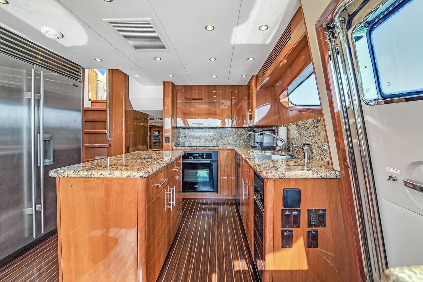 a kitchen with wooden cabinets aboard HATTERAS 80 MOTOR Yacht for Sale