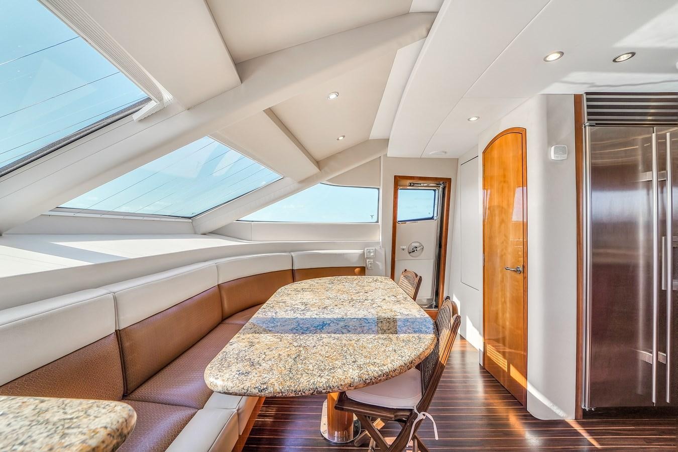 a room with a table and chairs aboard HATTERAS 80 MOTOR Yacht for Sale