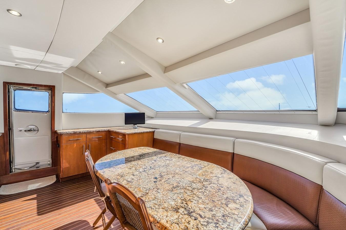 a room with a table and chairs aboard HATTERAS 80 MOTOR Yacht for Sale