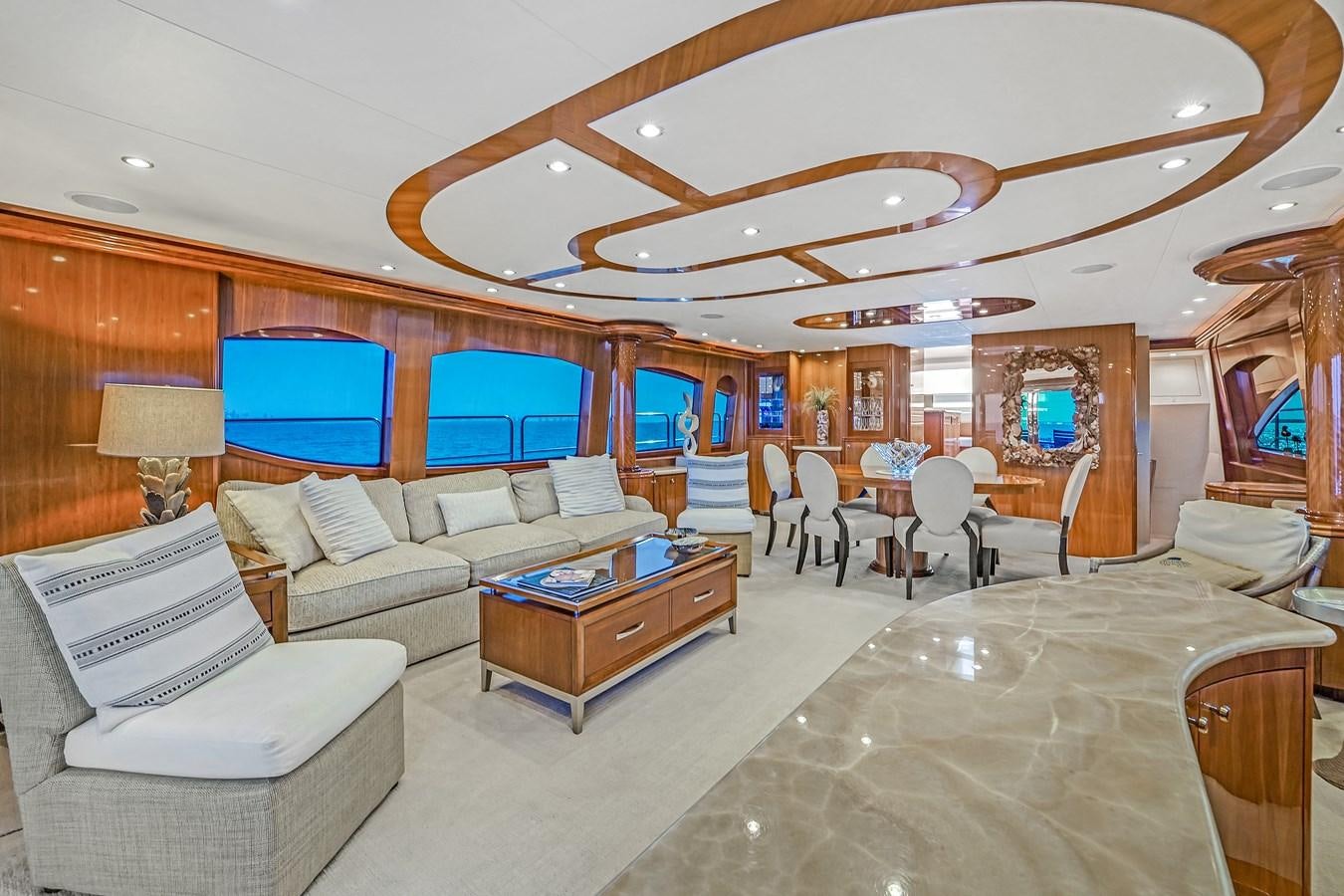 a room with a couch and a table and chairs aboard HATTERAS 80 MOTOR Yacht for Sale