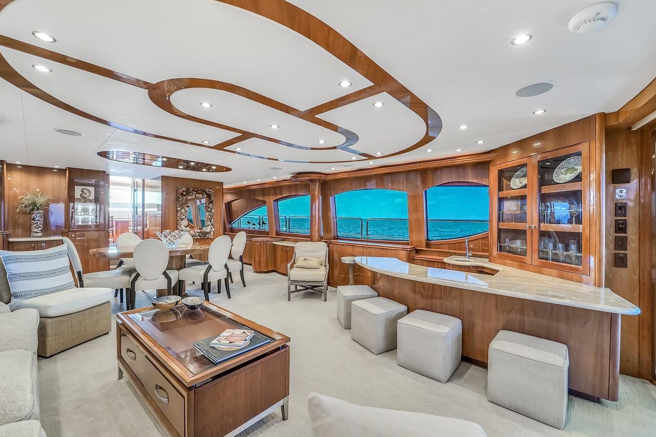 a room with a table chairs and a large window aboard HATTERAS 80 MOTOR Yacht for Sale