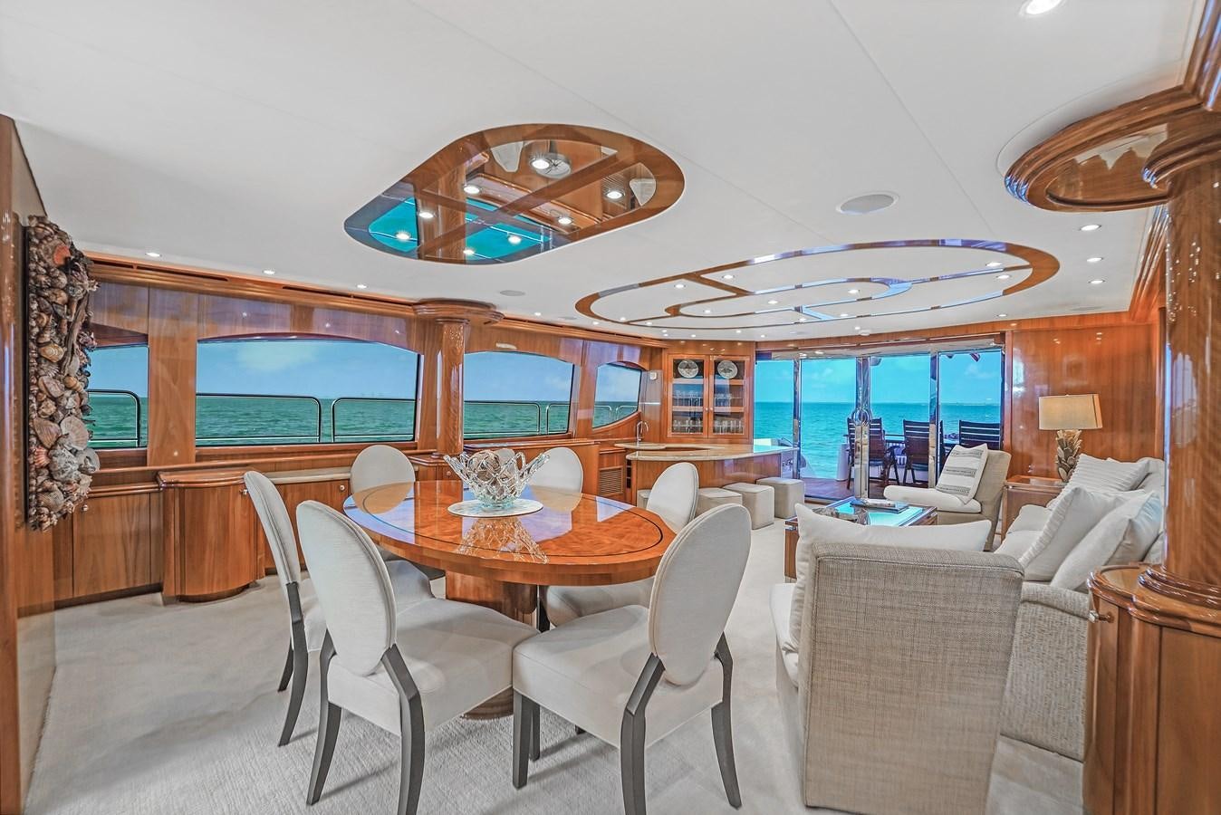 a large room with a table and chairs and a large chandelier aboard HATTERAS 80 MOTOR Yacht for Sale
