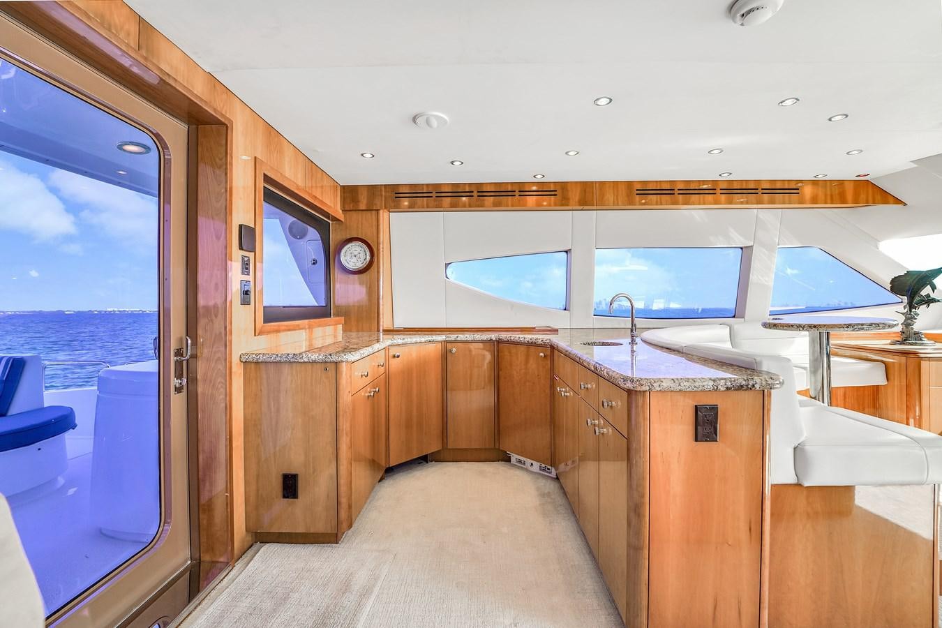 a room with a large window and a wood cabinet and a wood cabinet aboard HATTERAS 80 MOTOR Yacht for Sale