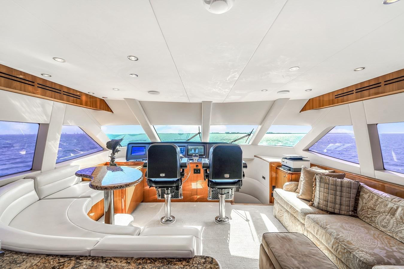 a room with a couch and a table and a chair aboard HATTERAS 80 MOTOR Yacht for Sale
