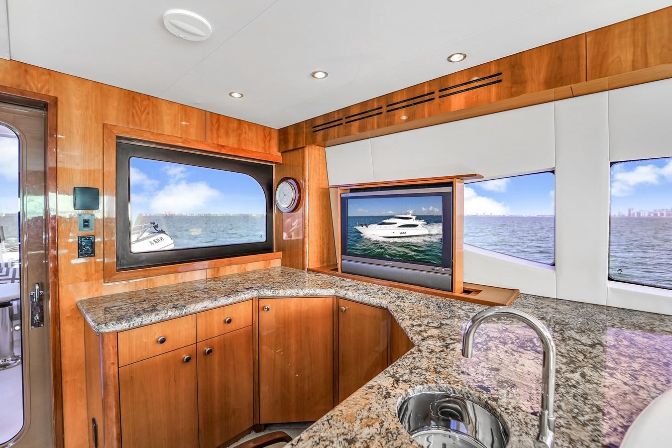 a kitchen with a large television aboard HATTERAS 80 MOTOR Yacht for Sale
