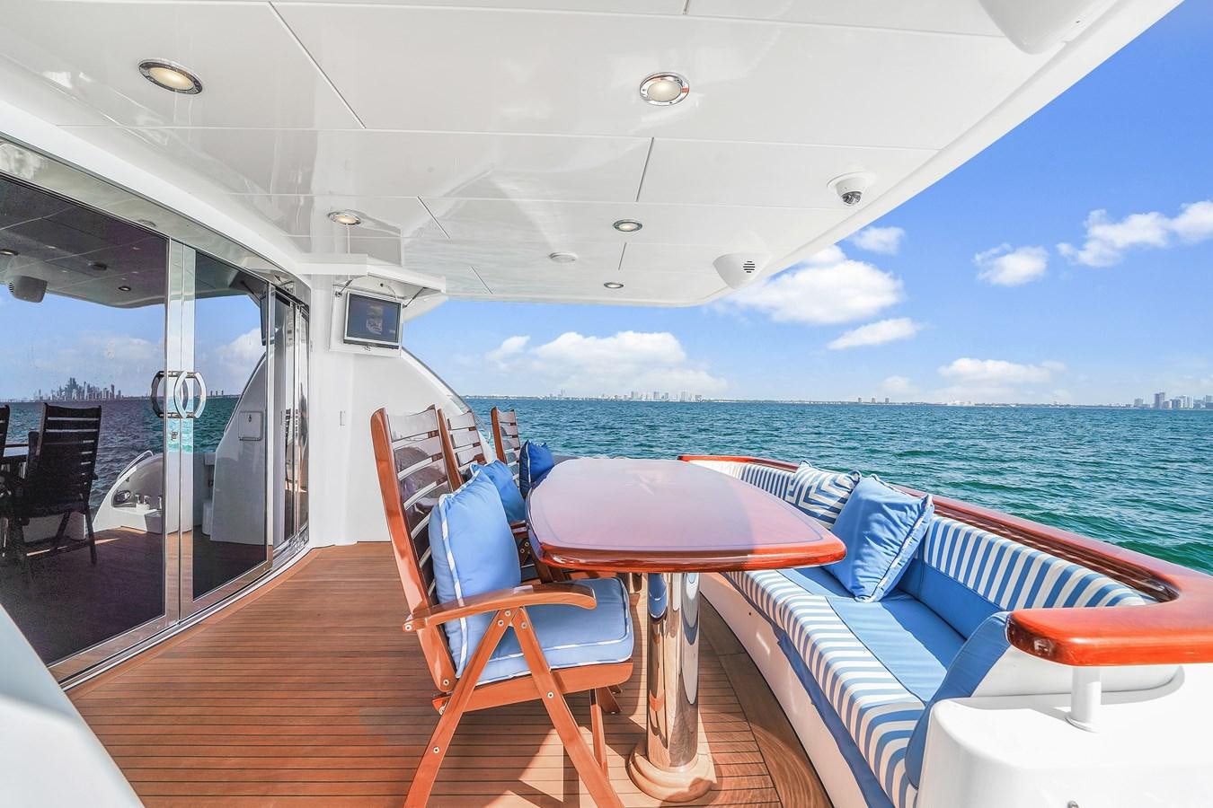 a boat with a table and chairs on a deck aboard HATTERAS 80 MOTOR Yacht for Sale