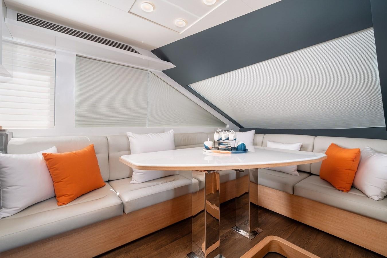 a white couch and a table in a room with white walls aboard CLB 72 Yacht for Sale