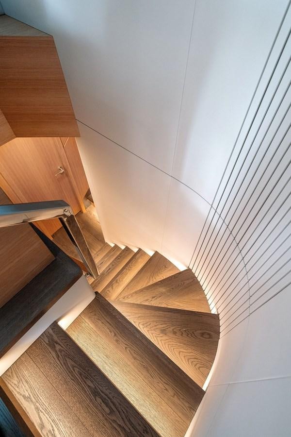 a wooden staircase with a white wall aboard CLB 72 Yacht for Sale