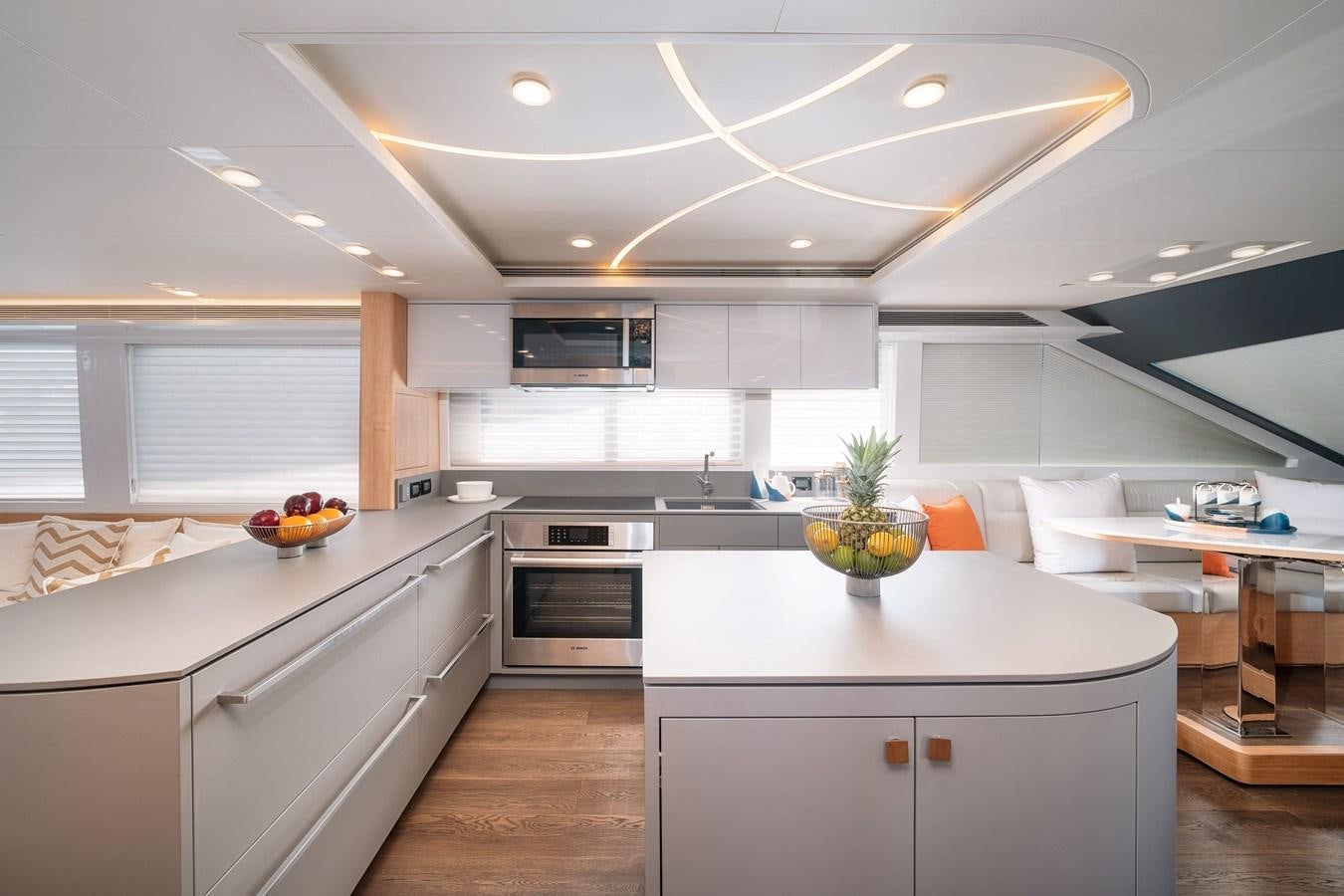 a kitchen with white cabinets aboard CLB 72 Yacht for Sale