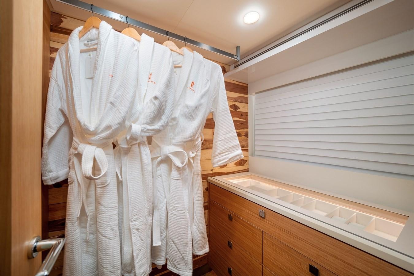 a row of white robes on a door aboard CLB 72 Yacht for Sale