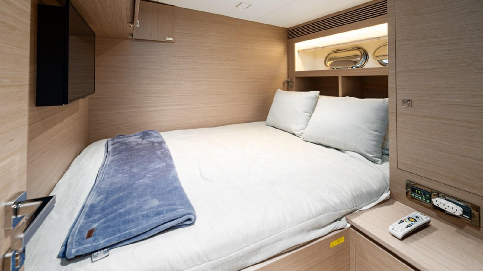a bed with a white sheet and a blue pillow on it aboard 90 HORIZON Yacht for Sale