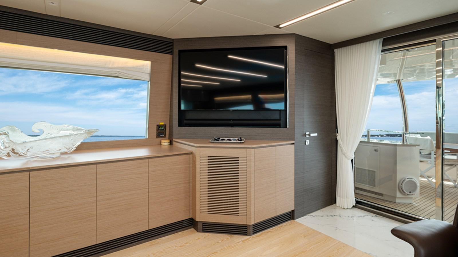 a room with a tv and a window aboard 90 HORIZON Yacht for Sale
