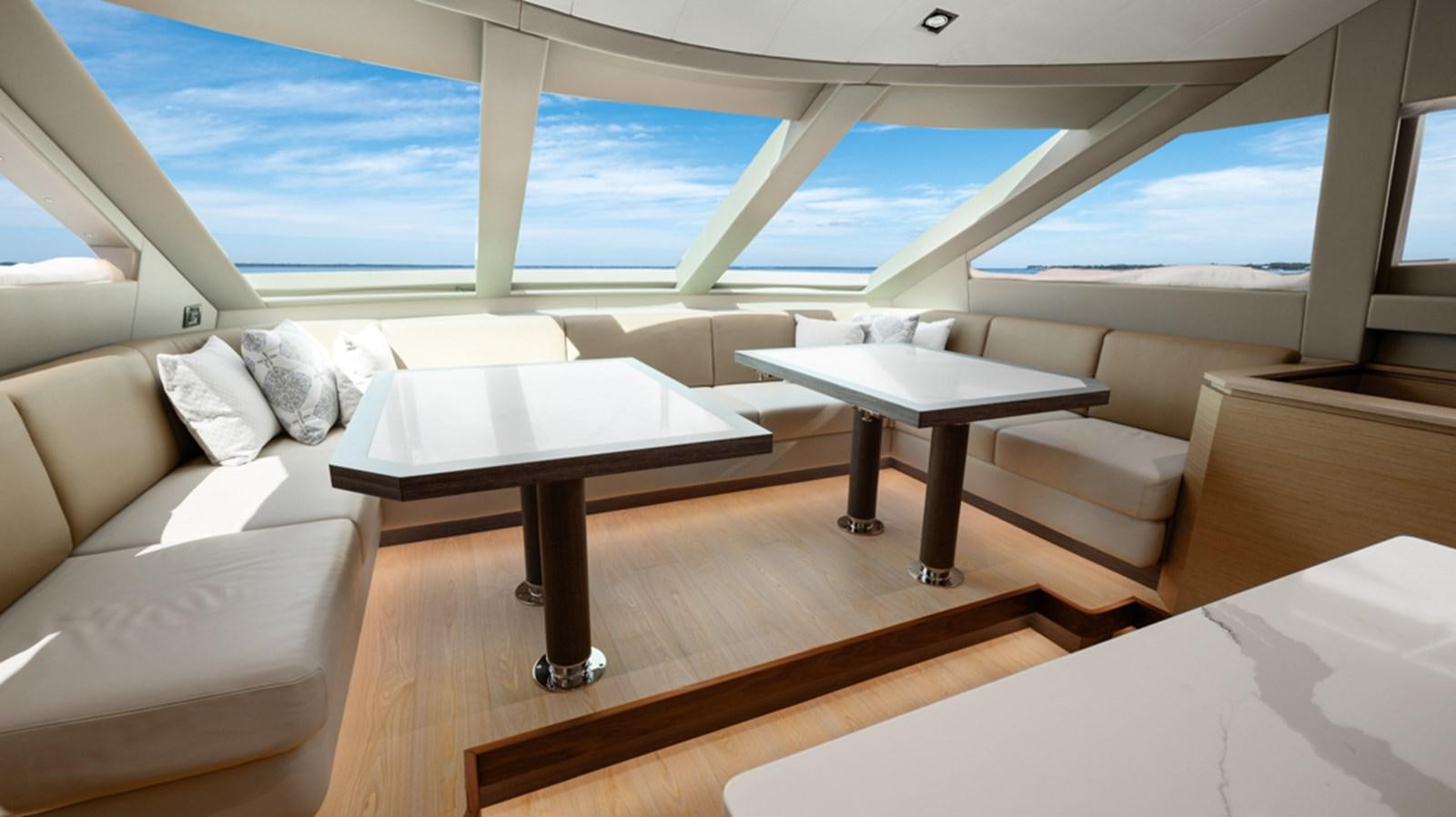 a room with a table and couch aboard 90 HORIZON Yacht for Sale