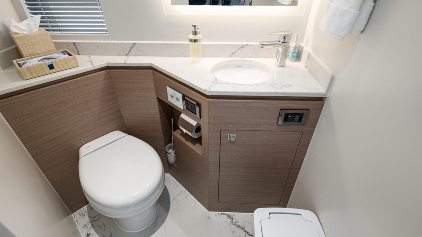 a bathroom with a toilet sink and a mirror aboard 90 HORIZON Yacht for Sale