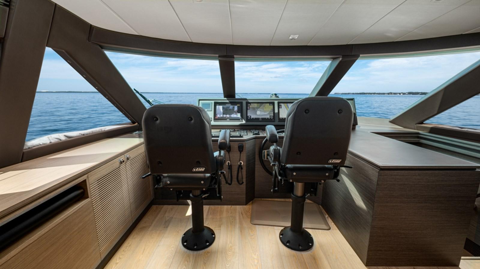 a room with a chair and a table and a window aboard 90 HORIZON Yacht for Sale