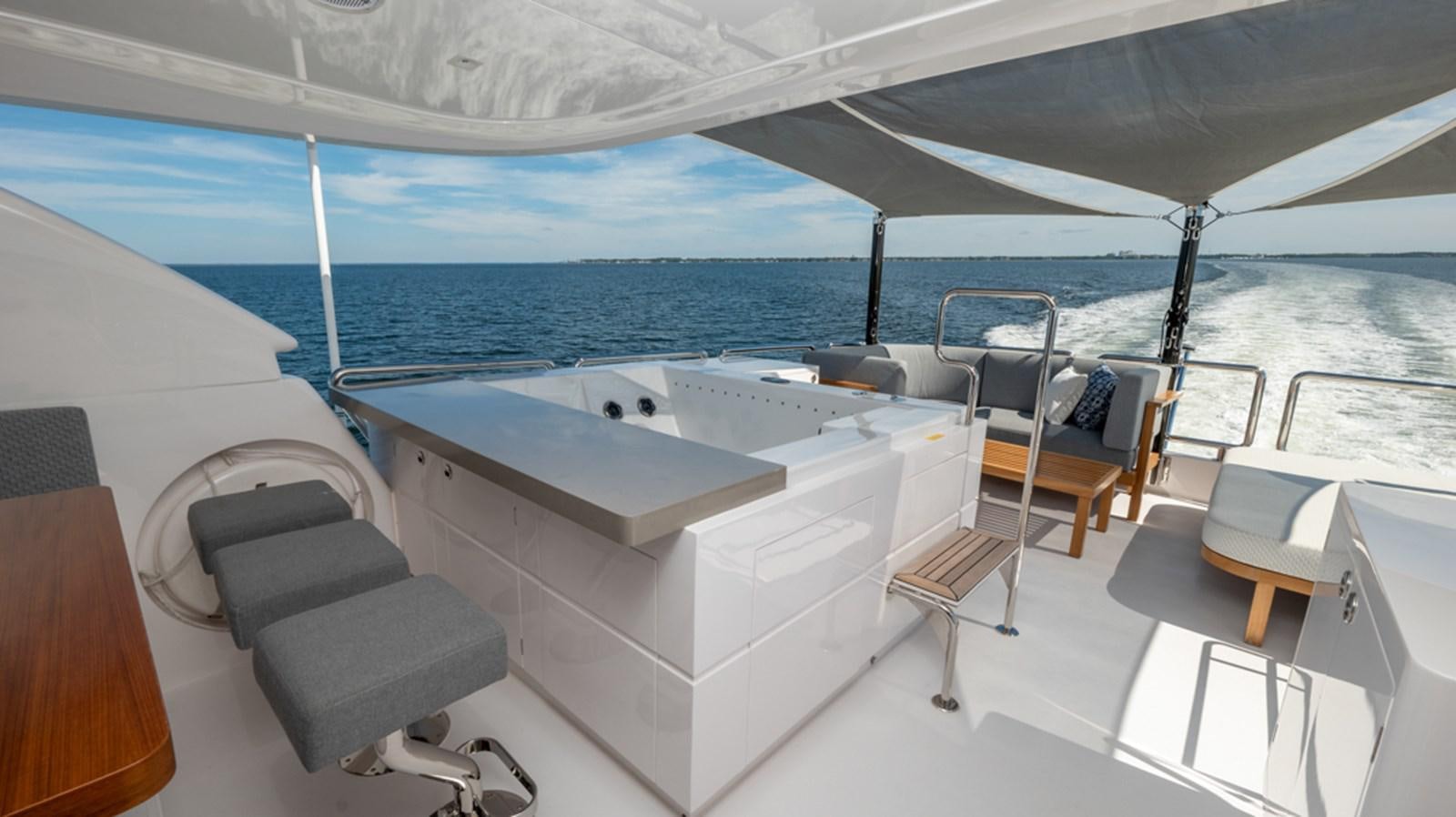 a room with a large white bed and a table with chairs on it aboard 90 HORIZON Yacht for Sale