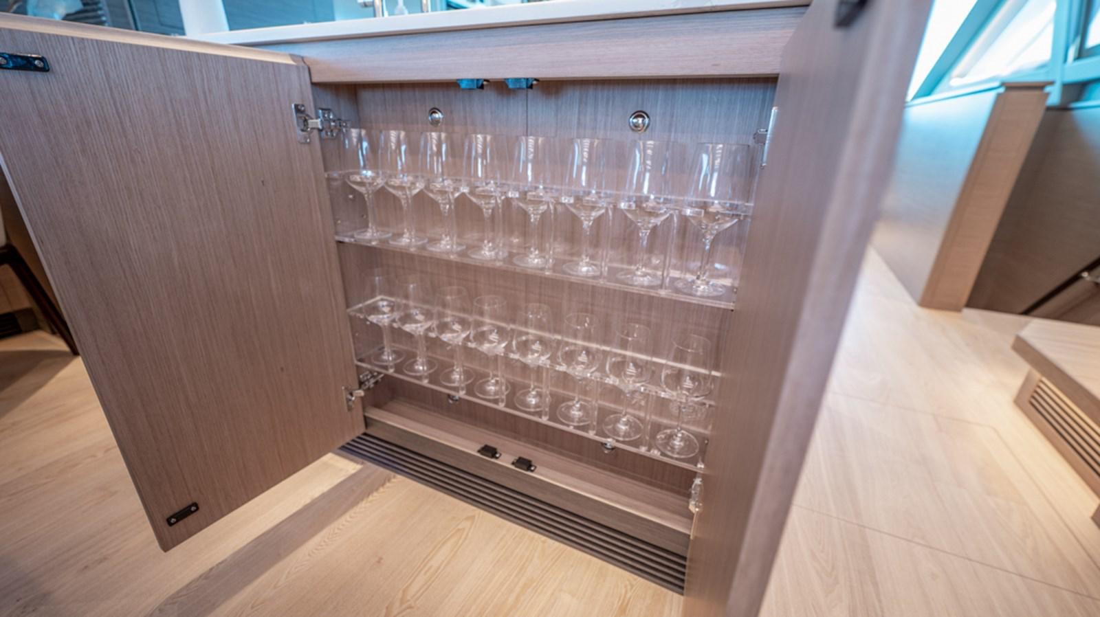 a wine cabinet with wine glasses aboard 90 HORIZON Yacht for Sale