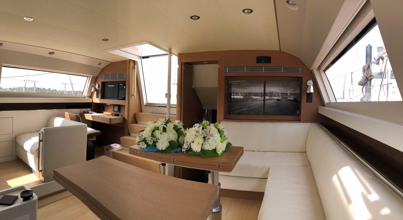 a living room with a table and chairs aboard TROIS VIGNES Yacht for Sale