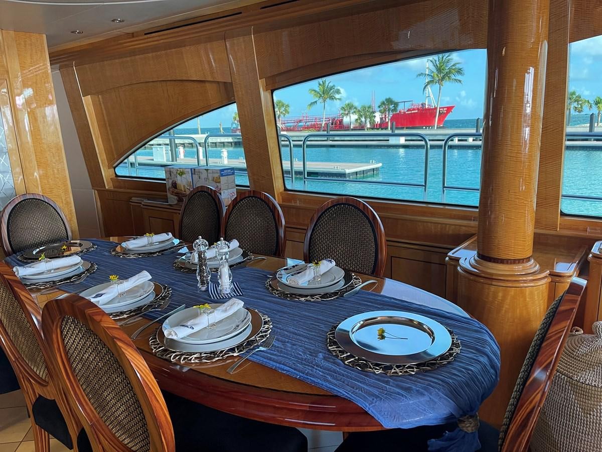 a dining table with plates and chairs aboard ARETECTE Yacht for Sale