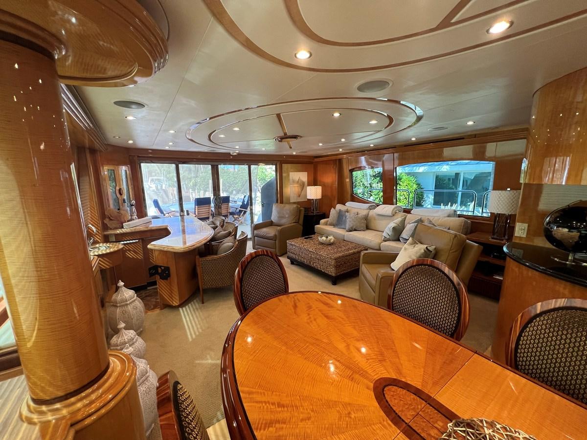 a large living room with a large dining table and a large window aboard ARETECTE Yacht for Sale