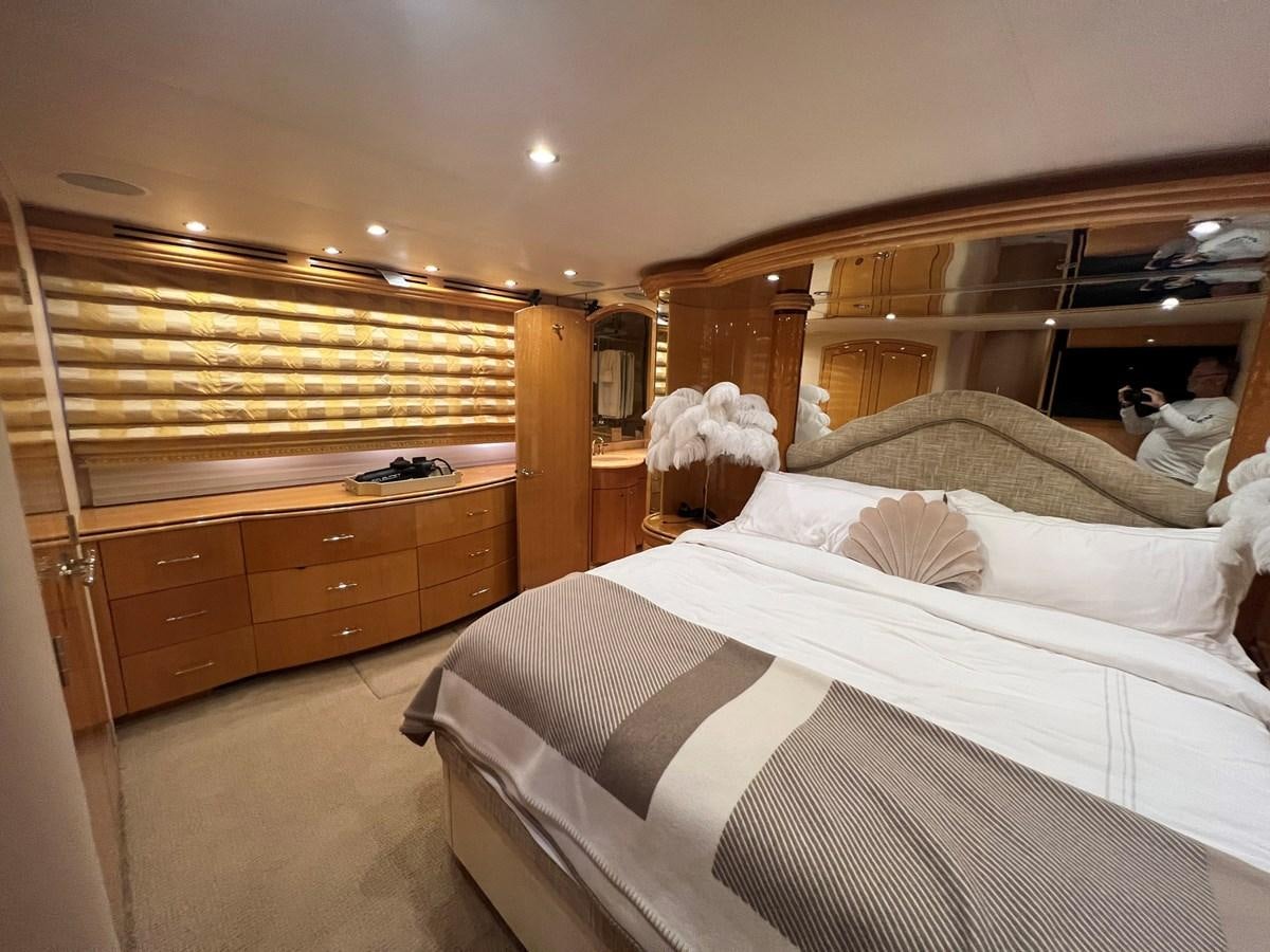 a bedroom with a bed and dresser aboard ARETECTE Yacht for Sale