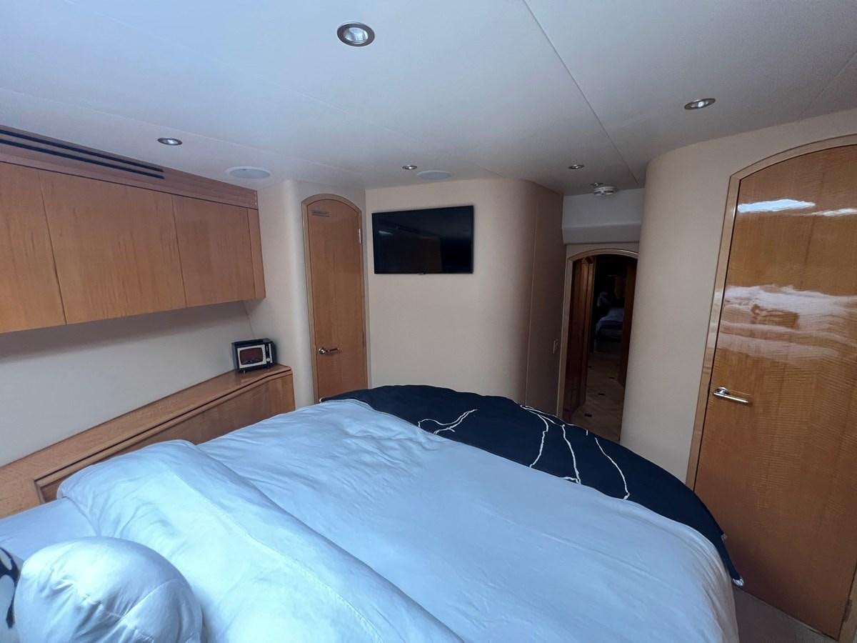 a bedroom with a bed and a television on the wall aboard ARETECTE Yacht for Sale