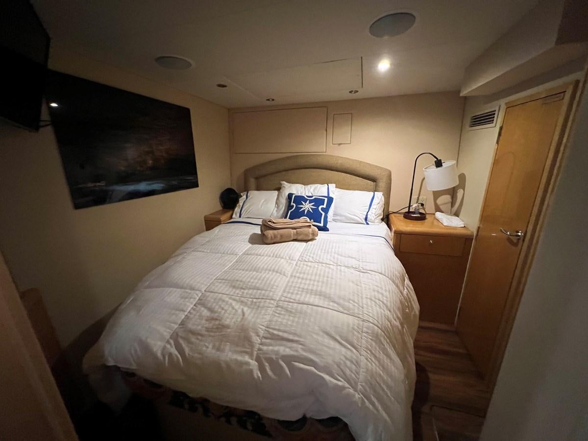 a bedroom with a bed and a lamp aboard ARETECTE Yacht for Sale