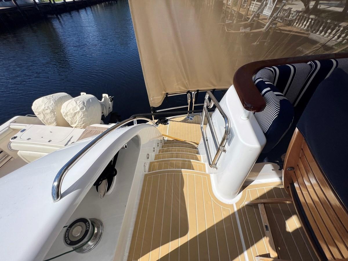 a wooden boat with a white sail aboard ARETECTE Yacht for Sale
