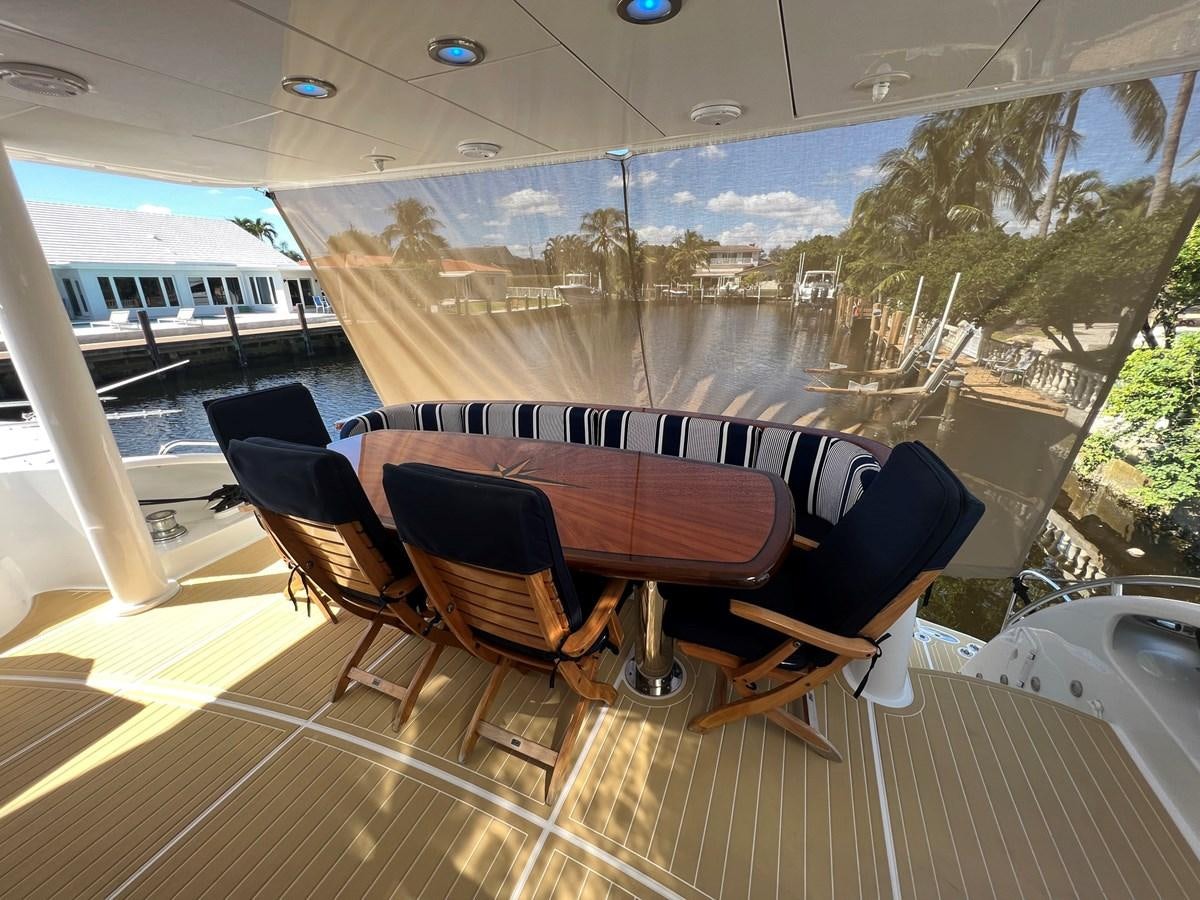 a table and chairs on a deck overlooking a city aboard ARETECTE Yacht for Sale