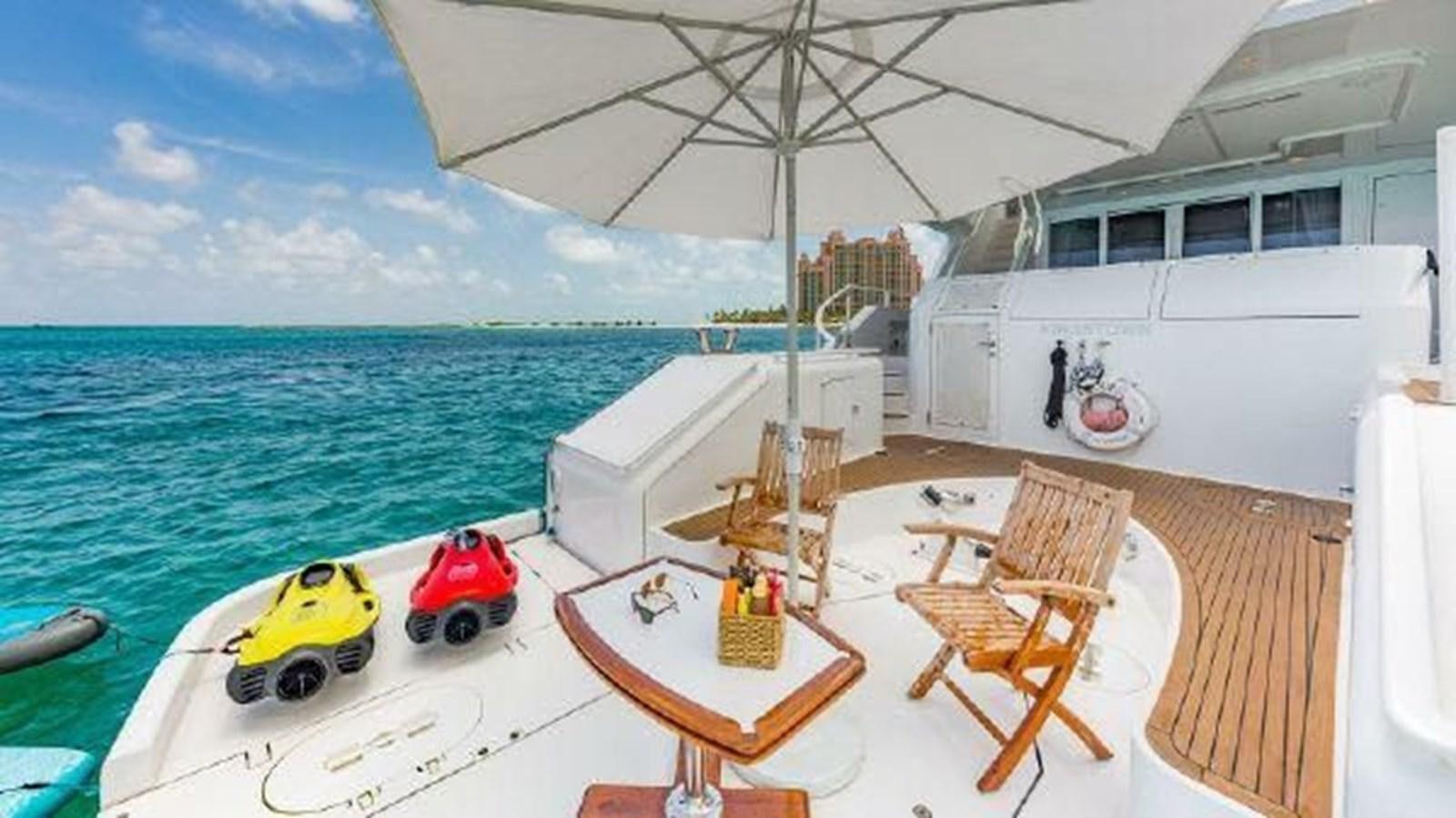a boat with a table and chairs on it by the water aboard ROGUE Yacht for Sale