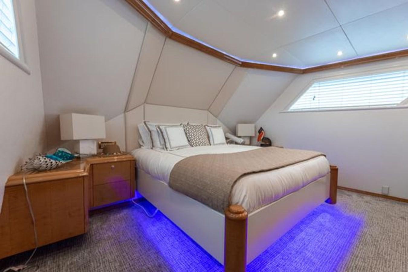 a bedroom with a bed and a desk aboard ROGUE Yacht for Sale