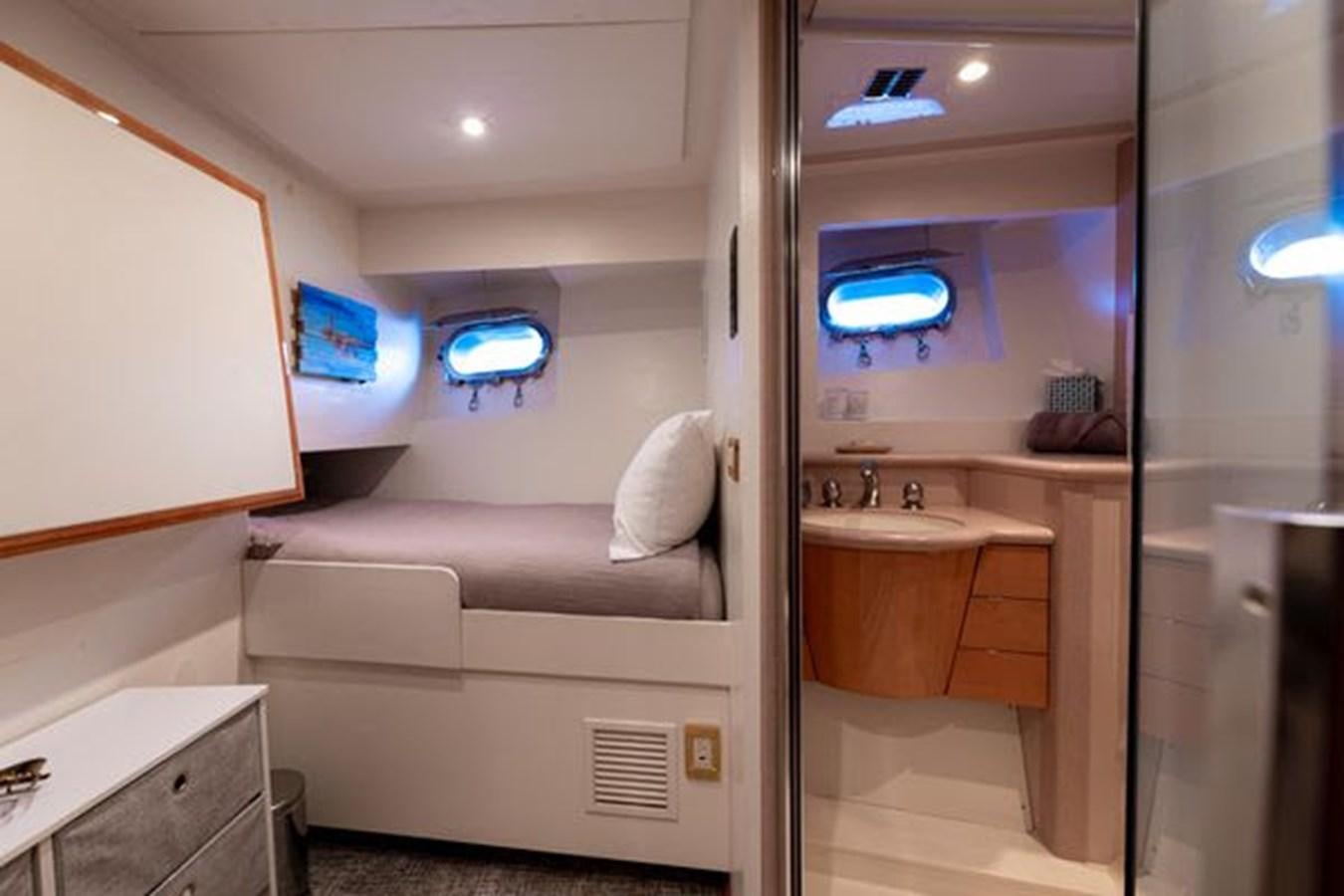 a small room with a bed and a sink aboard ROGUE Yacht for Sale