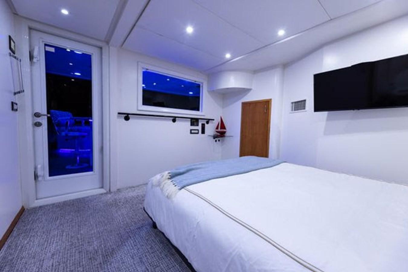 a room with a bed and a television aboard ROGUE Yacht for Sale