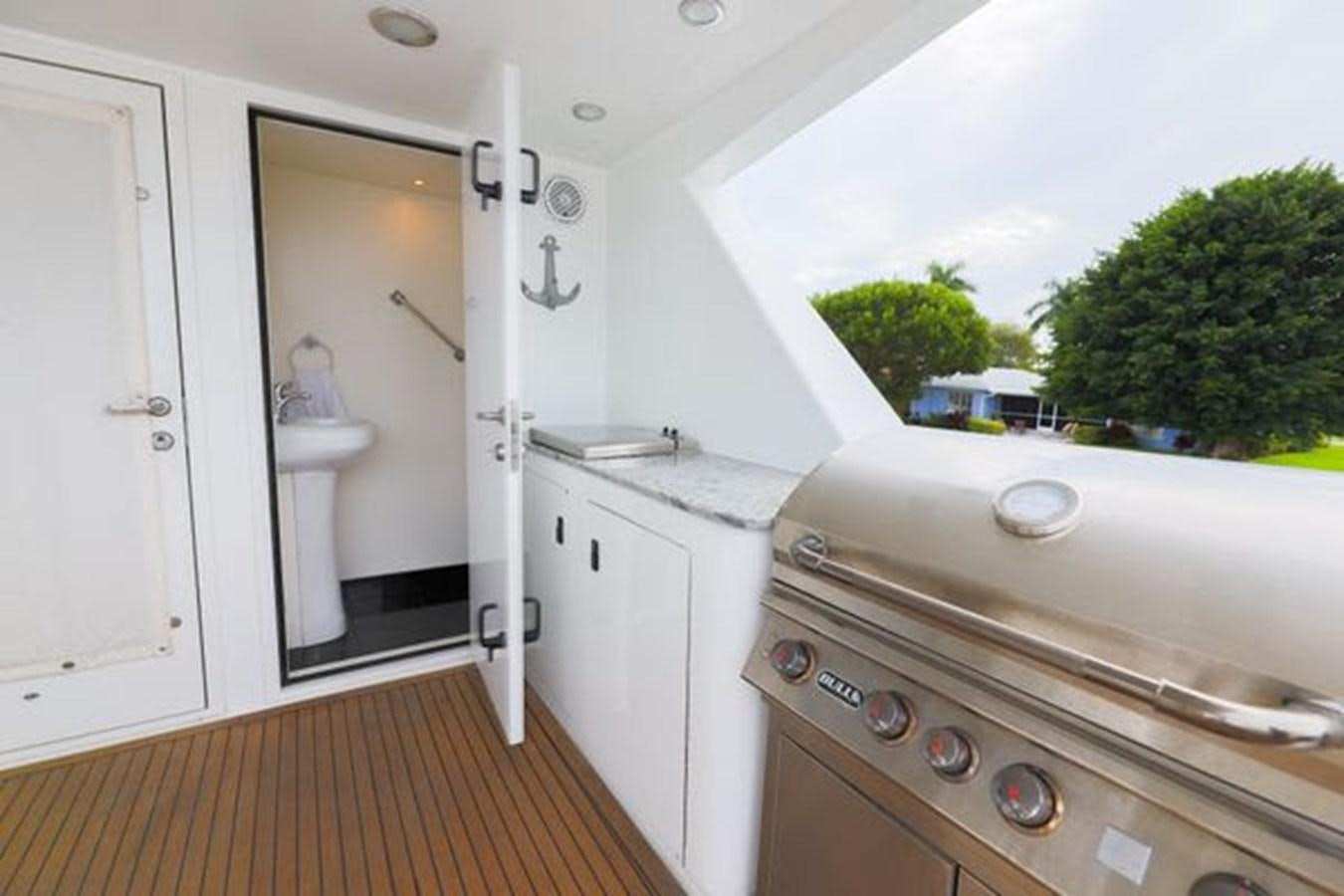 a white bathroom with a wood floor aboard ROGUE Yacht for Sale