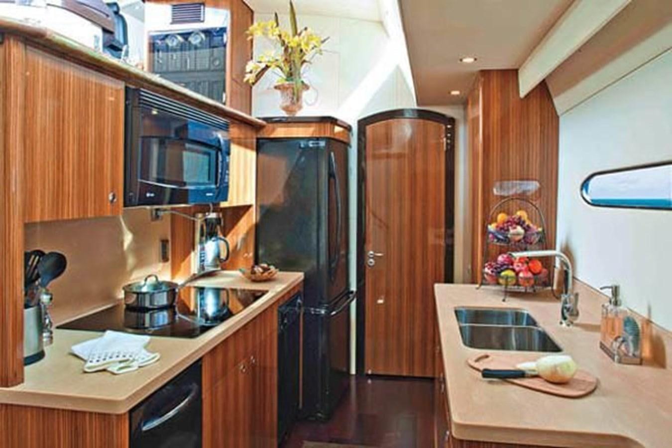 a kitchen with a black refrigerator aboard 2010 CUSTOM AXCELL  650 POWER CATAMARAN Yacht for Sale