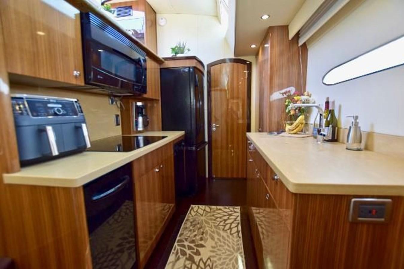 a kitchen with wooden cabinets aboard 2010 CUSTOM AXCELL  650 POWER CATAMARAN Yacht for Sale