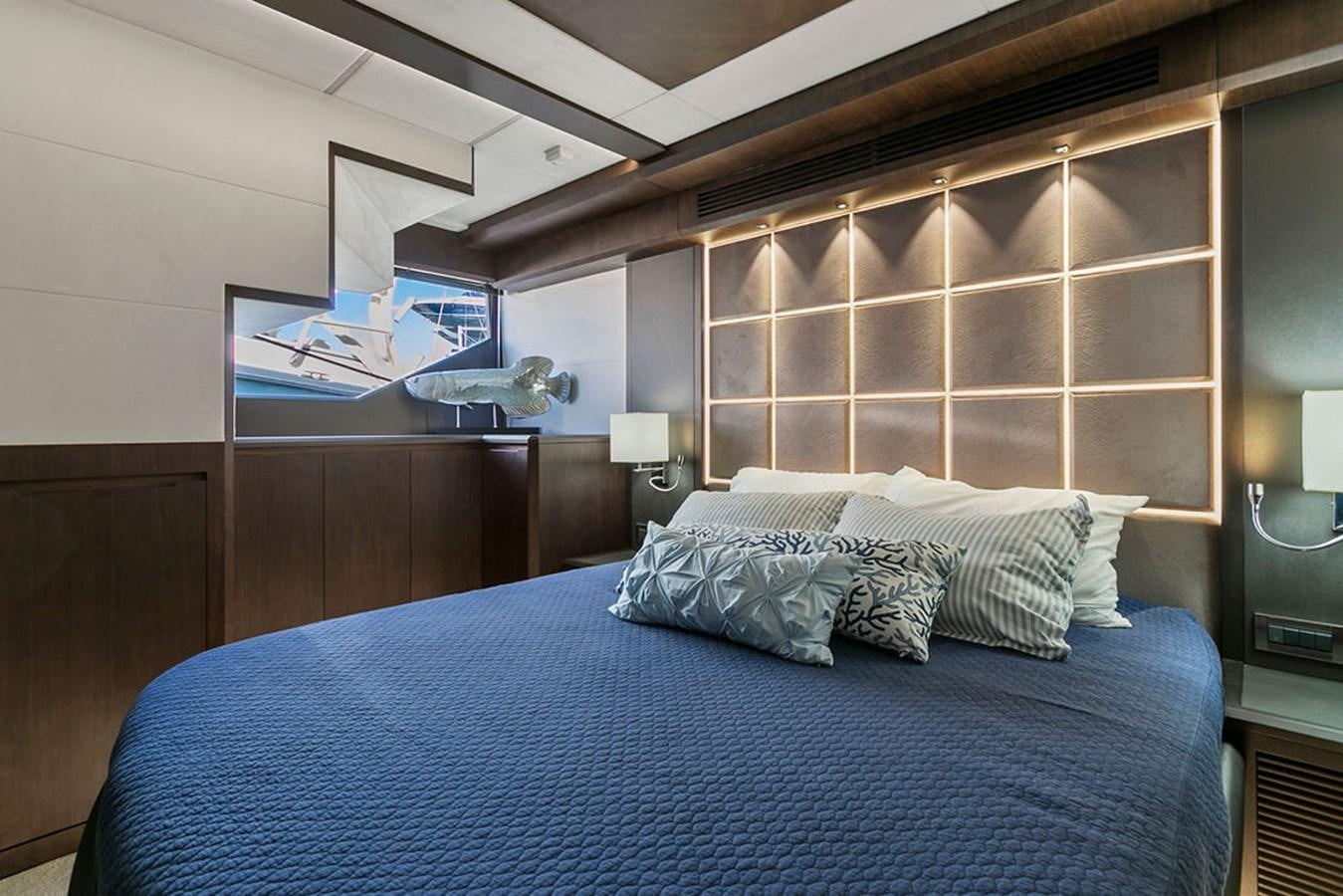 a bed with a blue comforter aboard NOKOKO Yacht for Sale