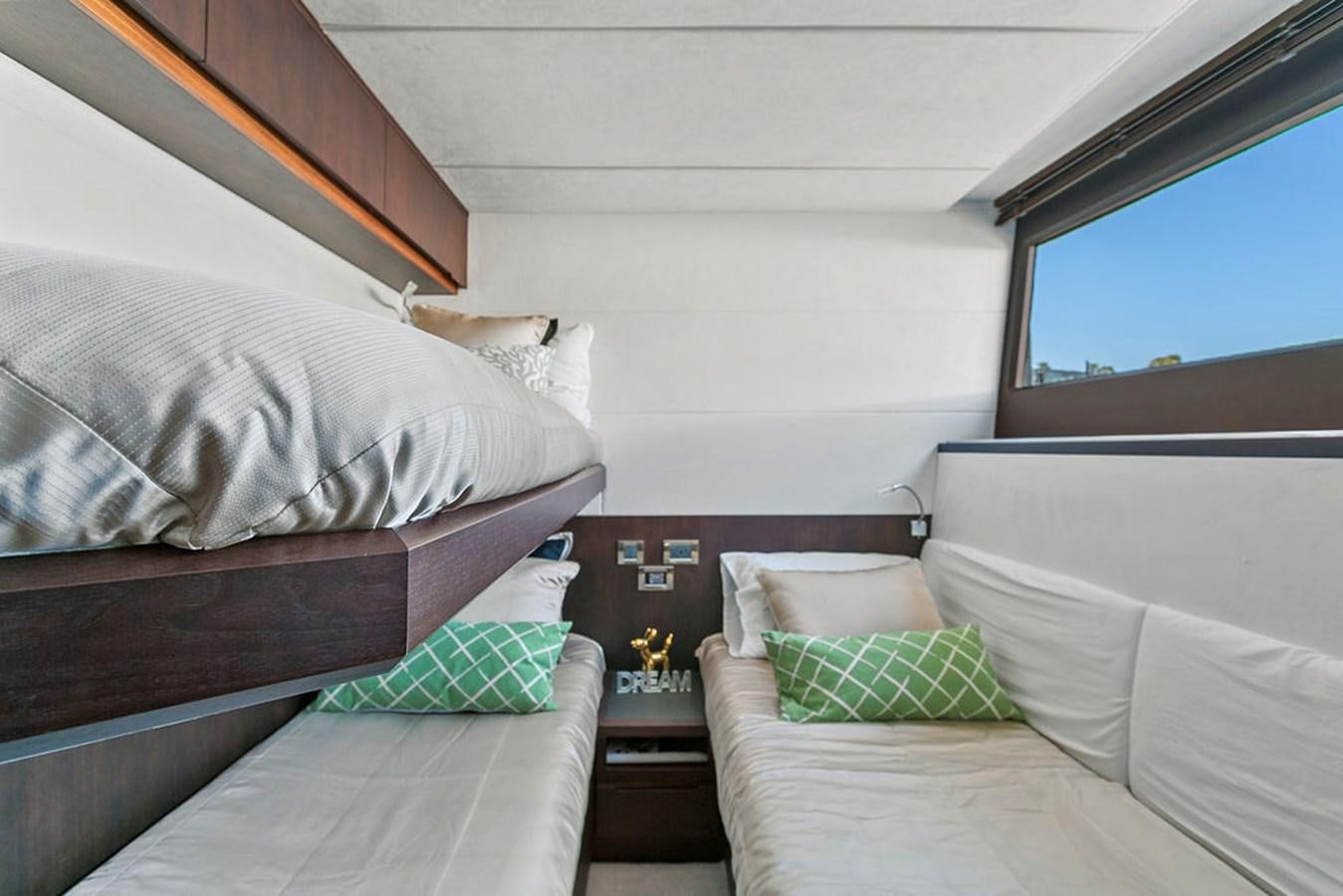 a bedroom with a bed and a window aboard NOKOKO Yacht for Sale