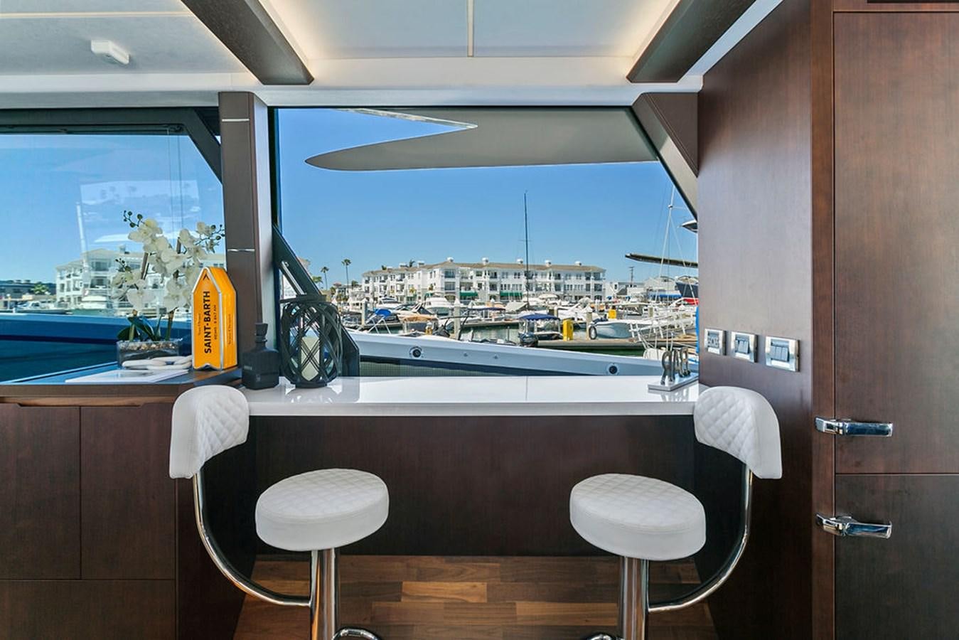 a room with a window and a desk with chairs and a view of the city aboard NOKOKO Yacht for Sale