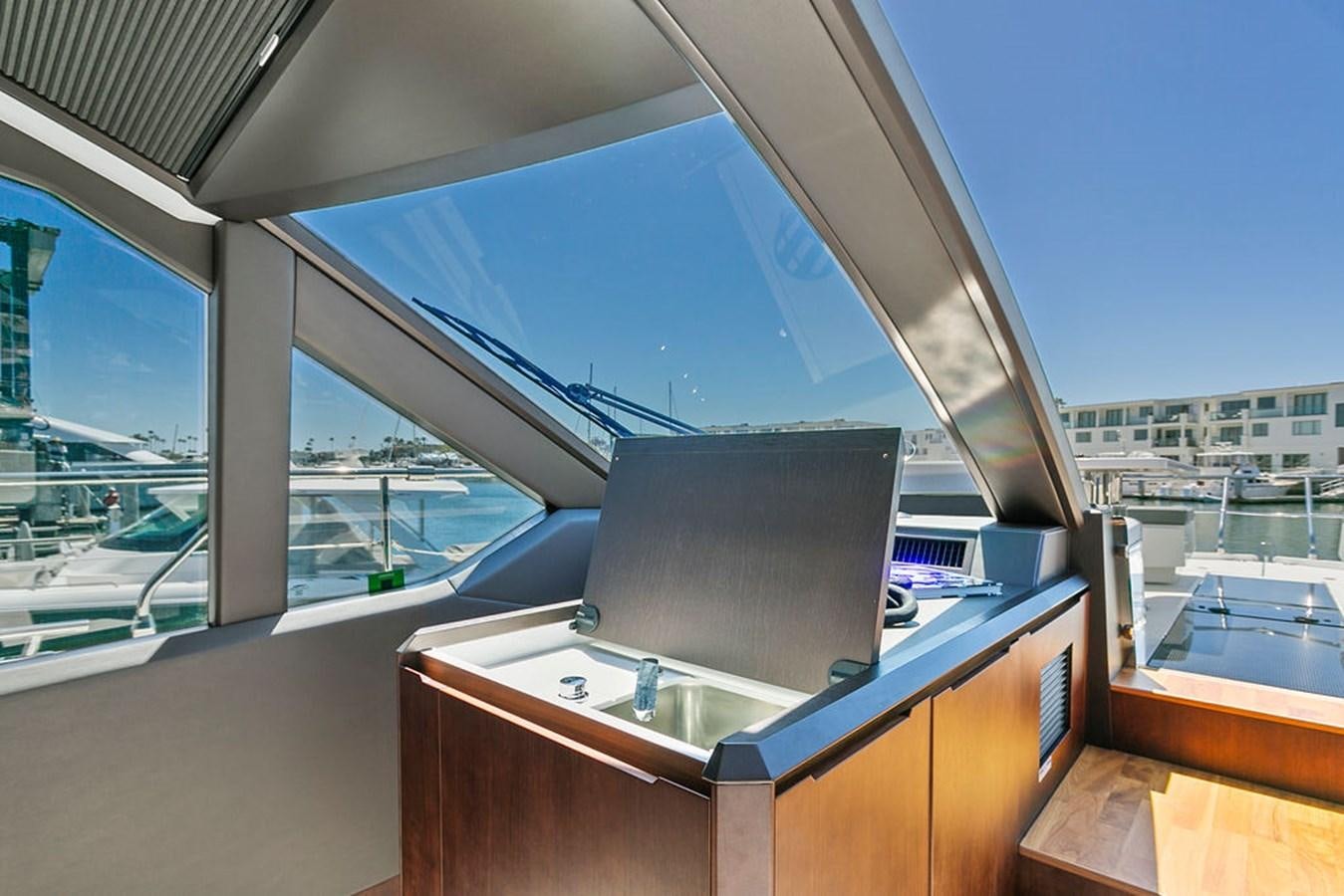 a room with a large window and a table with a laptop on it aboard NOKOKO Yacht for Sale