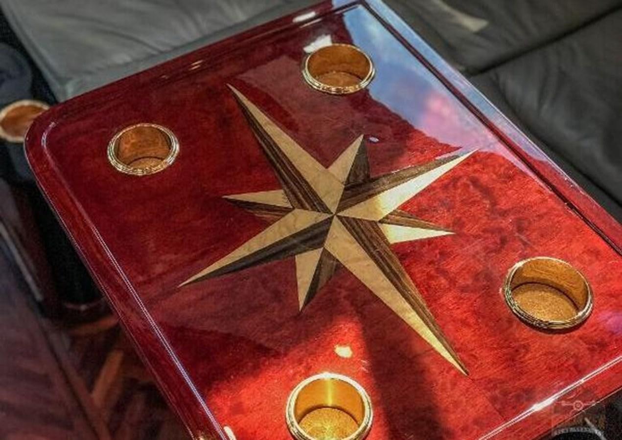 a red and white table with a red tablecloth and a silver plate with gold and silver coins aboard DREAM CATCHER Yacht for Sale