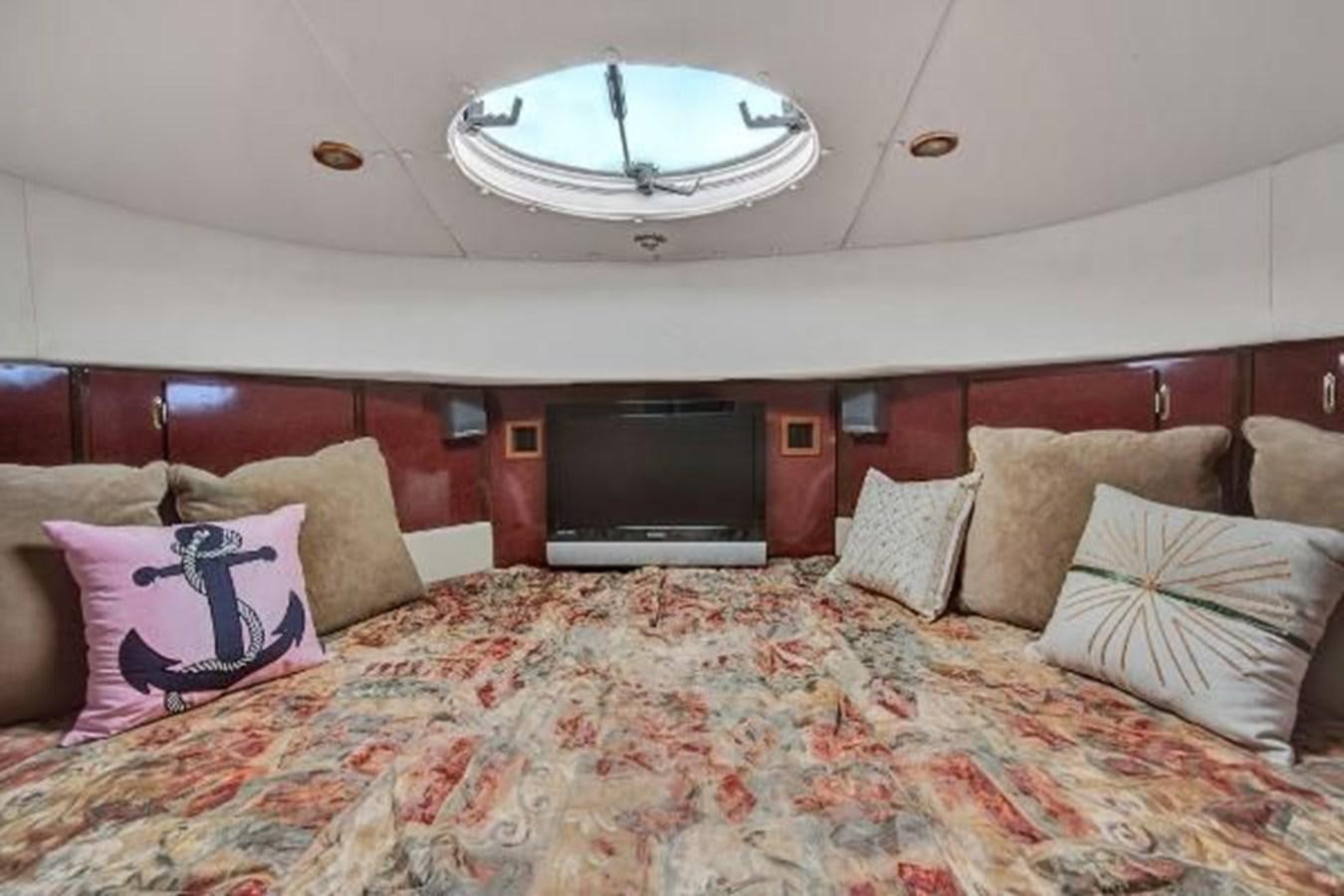 a bed with pillows and a television aboard DREAM CATCHER Yacht for Sale