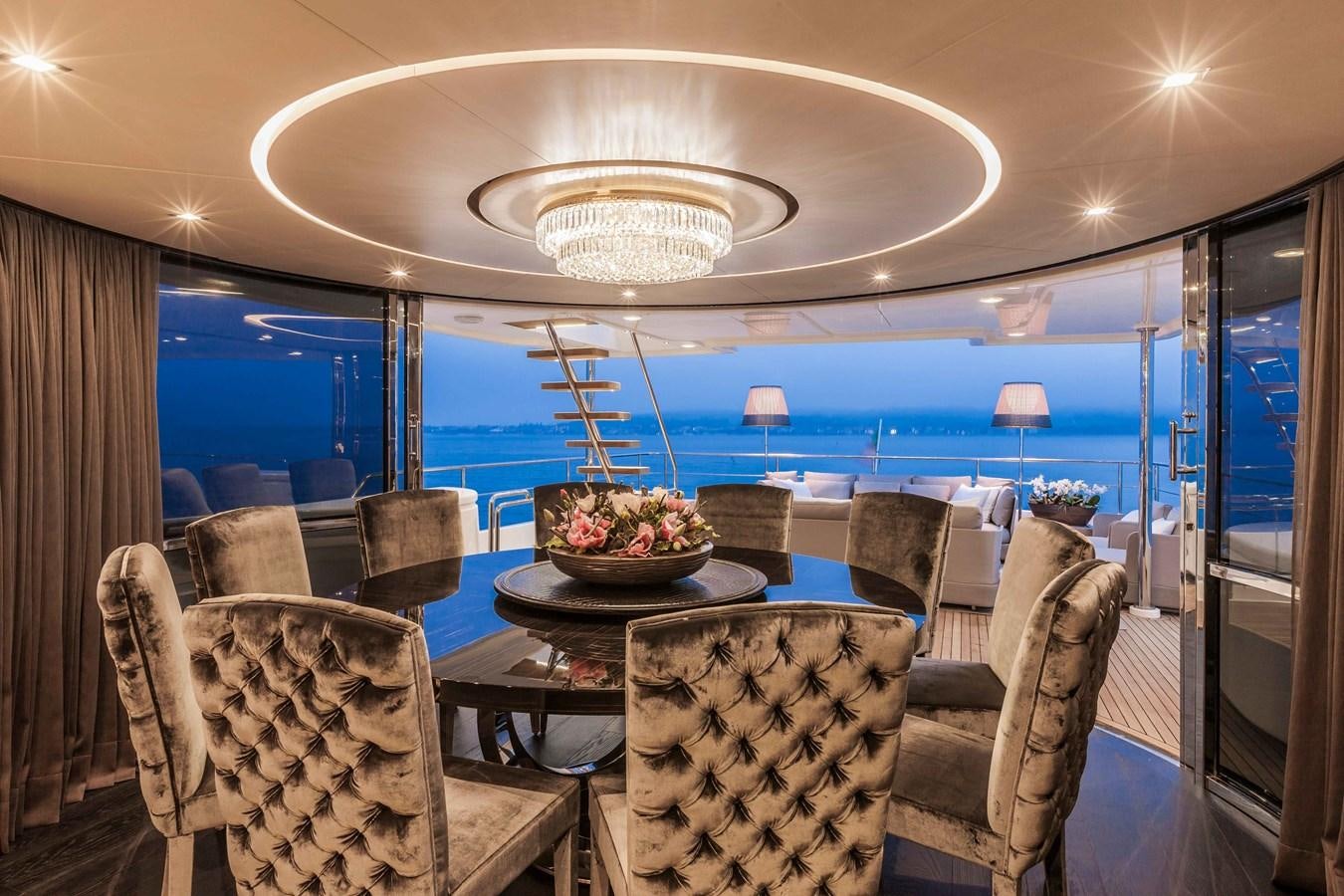a room with a table chairs and a large chandelier aboard YVONNE Yacht for Sale