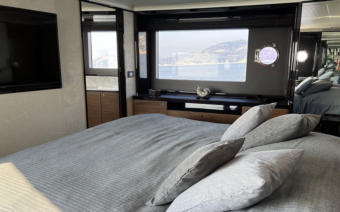 a bed with a white sheet and pillows in a room with a television aboard A4A Yacht for Sale