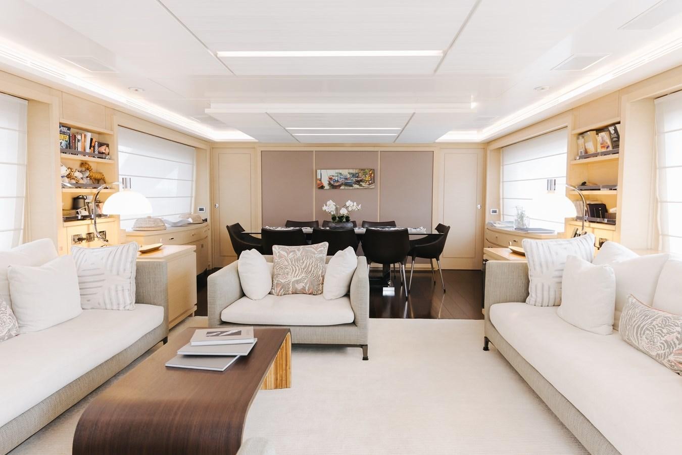 a living room with a table and couches aboard LIBERTY CALL Yacht for Sale